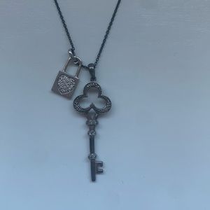 Lock and key silver necklace on a black chain